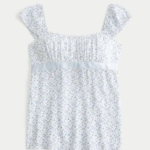 Söt babydoll topp från hollister!! - Supersöt topp i vitt med små blå blommor, volangärmar och ljusblå rosett i ryggen. Har använt 1-2 ggr o är i nyskick. Säljer pga fel storlek till mig. Helt slutsåld i strl xxs, xs o s på hemsidan!