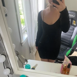 Svart stickad kortklänning H&M - Svart stickad klänning från H&M med lång ärm och djup v-ringning. Den är väldigt skön att ha på sig och är i väldigt fint skick❤️Det står inte vilken storlek det är men jag kan tänka mig att det är storlek S kanske