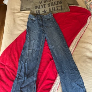 Wide ultra high waist jeans från &Denim - Blå jeans med riktigt breda ben och ultra hög midja från &Denim. Klassisk femficksmodell med raka sömmar och snygg denimtvätt. Perfekt för dig som gillar loose fit och vill ha en cool, avslappnad look. Passar dig som vill sticka ut med bred siluett. Använder inte dom längre tyvärr. Super sköna jeans och inte slitna alls. Jag är 163 och dom sitter super bra i längden.