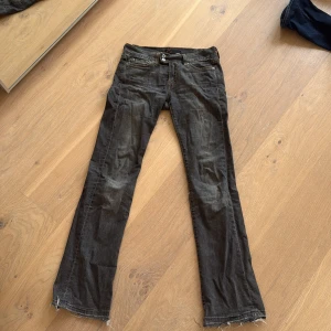 Svarta bootcut jeans med slitna benslut - Säljer ett par svarta jeans med bootcut passform och låg midja. Jeansen har slitna benslut och klassiska fickor med snygga sömmar bak. Perfekta för dig som gillar en avslappnad och cool stil.💗
