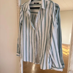 Randig skjorta från Bik Bok, stl S - Snygg skjorta från Bik Bok i storlek S med vita och gröna vertikala ränder. Skjortan har klassisk krage, långa ärmar och knäppning framtill. Perfekt för en chill och stilren look. Tillverkad i mjuk bomull som känns skön mot huden.