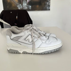 New Balance 550 vita sneakers - Säljer ett par New Balance 550 sneakers i vitt med grå detaljer. De kan behöva putsas upp lite, men det finns inga större fel på skorna. Super sköna skor som sitter som en smäck🫰