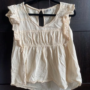 Blus - Söt blus med korta volangärmar från hunkydory. Beige/baby rosa färg.