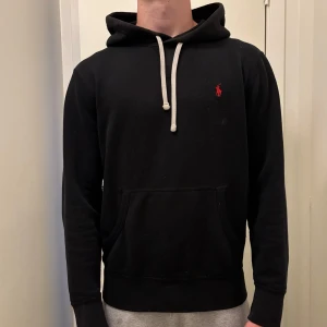 Ralph Lauren hoodie - Svart hoodie från Polo Ralph Lauren med klassisk röd broderad logga på bröstet. Tröjan är näst intill ny och är inte använd mycket. Hör av er vid frågor/prisförslag!