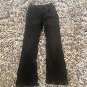 Svarta bootcut jeans från Denim Day - Snygga svarta jeans från Denim Day i storlek 152. Modellen har bootcut-ben och klassisk femficksdesign. Jeansen är tillverkade i denim och har knapp och dragkedja framtill. Perfekta för dig som gillar en tidlös look med lite utsvängda ben. och har bara använt dom 2 gånger 