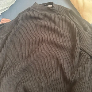 Svart ribbad stickad - Säljer en svart tröja med öppna axlar.