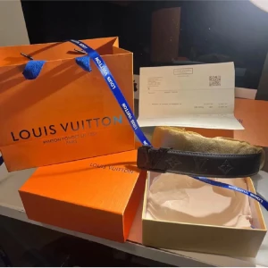 Svart bälte  - Säljer ett svart bälte med klassiskt monogrammönster och svartfärgat spänne. Bältet levereras i originalförpackning med tillhörande påse och box. Perfekt accessoar för att lyfta din outfit. Det finns nån fläck därför de billiga priset. PRIS KAN DISKUTERAS!🙃