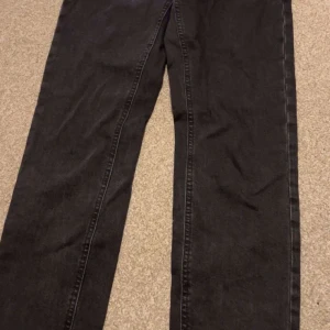 Svarta raka jeans - Säljer ett par svarta jeans med rak passform. Klassisk femficksmodell och normal midja. Perfekta till vardags och lätta att matcha med olika stilar.
