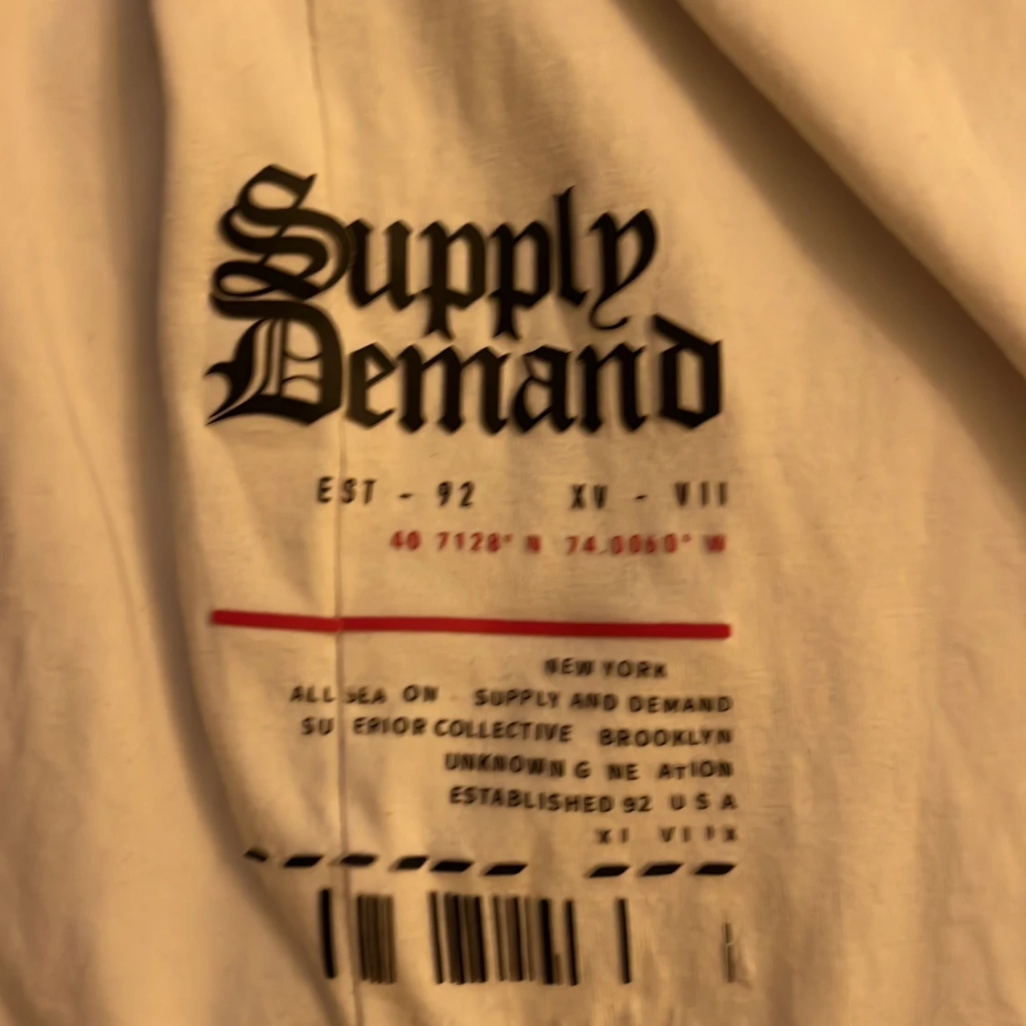 Vit t-shirt med svart text från Supply & Demand - 1
