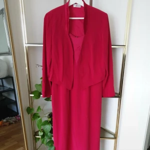 Röd långklänning med matchande jacka - Säljer en röd långklänning med smala axelband och v-ringning, tillsammans med en matchande jacka i samma färg. Klänningen har en elegant och enkel design, perfekt för speciella tillfällen. ❗Mer information och bilder på Vinted