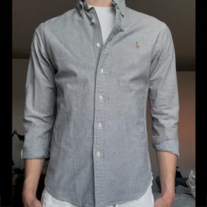Grå oxfordskjorta från Ralph Lauren - Grå oxfordskjorta.                                                                   Helt oanvänd, storlek S, slim fit                                           Kontakta för mer info!