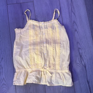 Gul linnetopp med spetsdetaljer från Lindex - Säljer denna fina sommar top från Lindex. Super skön och helt ny bara provad! Säljer för den sitter konstigt på min. Köpt för 150kr💞💞