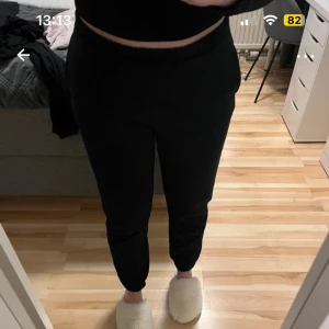 Svarta mjukisbyxor med resårmidja - Svarta mjukisbyxor med normal passform och resår i midjan. Byxorna har raka ben och är perfekta för en avslappnad stil. Tillverkade i mjukt material som känns skönt mot huden. Från ginatricot.