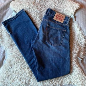 Levis 514 jeans - Säljer dessa sjukt snyggga blå Levis 514 jeans med raka ben och femficksmodell. Byxorna har en true normal passform som verkligen hålls upp av materialet, knappgylf och tydlig Levis-lapp bak i midjan. Perfekta för dig som gillar tidlös denimstil och vill ha något som passar till allt. Finns inga större tecken på användning förutom att lite av detaljerna försvunnit som man kan se på sista bilden, skick 9/10. Tveka inte på att höra av dig vid frågor eller funderingar! ⭐️