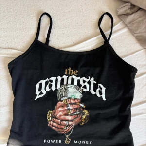 Svart linne - Svart linne med smala axelband och tryck framtill. 