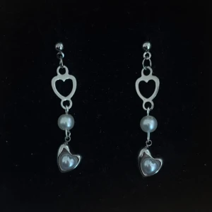 Silverfärgade örhängen med hjärtan och pärlor - Handgjorda och unika silverörhängen  🤩 Hela örhänget är i 100% rostfritt stål (ej silverpläterat) 💕🙏5 cm långa. Alla köp görs via ”KÖP NU” knappen.  💐