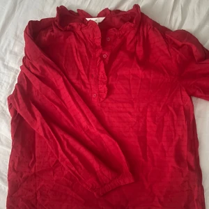 Röd blus med volang från H&M - Röd blus från H&M i nyskick, bara andvänd en gång.
