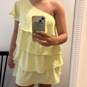 Ljusgul one shoulder klänning med volanger från Zara - Superfin ljusgul klänning från Zara med one shoulder och flera lager volanger. Använd ett fåtal gånger. Liten i storleken o passar mig som vanligtvis har stl S/M