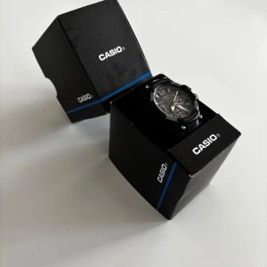 Svart analog digital klocka från Casio - Stilren svart klocka från Casio med både analog och digital visning. Klockan har robust design, tydliga siffror och detaljer i silver. Levereras i originalförpackning. Perfekt accessoar för dig som gillar sportig och modern stil.