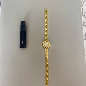 Elegant guldklocka  - Klockan är i ett mycket fint skick. Med ett sprillans nytt batteri och armbandet är justerbart så du enkelt kan justera armbandets originella storlek från 19 cm till vad du än vill.