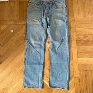 Levis 505 ljusblå jeans 32/32 - Klassiska Levis 501 jeans i ljusblå tvätt med raka ben och femficksdesign. Byxorna har knappgylf och den ikoniska Levis-lappen bak i midjan. Perfekta för en avslappnad stil och passar till det mesta.