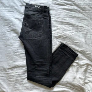 Svarta Dondup jeans  - Snygga svarta jeans från Dondup. Modellen är george skinny fit i storlek 31. Fin svart färg med lite fade. Inga skador eller hål. Kontakta gärna för mer info!