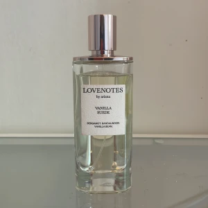 LOVENOTES Vanilla Suede Eau de Parfum - Ca 1 cm av använd produkt. En modern och sensuell parfym från Ariana Grandes LOVENOTES-kollektion. Doften har toppnoter av italiensk bergamott, hjärtnoter av sandelträ och rismjölk samt basnoter av vaniljböna och flytande mysk. Flaskan är genomskinlig med silverfärgad kork.