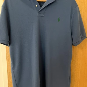 Ralph lauren piké  - Ralph lauren pike i storlek L men passar L/M. Använd ett par gånger så är i bra skick och formen är bra. Inga skador.
