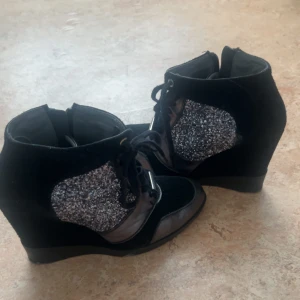 Svarta kilklack med glitterdetaljer - säljer dessa isabel marant liknande skor som är superfina, aldrig använt. de har en jättefin glittrig sida på skorna som passar perfekt för lite festliga grejer men även dagligen. vet tyvärr inte vart ifrån de kommer. pris går självklart att diskutera 