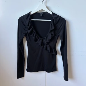 Svart långärmad topp med volang - Säljer min svarta långärmad tröja då den inte kommer till användning längre🩷