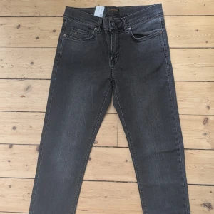 Grå jeans J.Lindeberg Damien Shadow - Helt oanvända jeans från J.Lindeberg, modell Damien Shadow. Klassisk femficksdesign, raka ben och normal passform. Jeansen är i en ljusgrå tvätt och tillverkade i mjukt bomullsmaterial med lite stretch för extra komfort. 