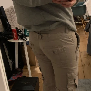 Lågmidjade cargo byxor - Jättesnygga lågmidjade cargobyxor med raka ben som är köpte här på Plick. Tyvärr passar de inte mig längre. På ena sidan saknas knapp som syns på sista bilden.  Använd gärna köp nu!💕