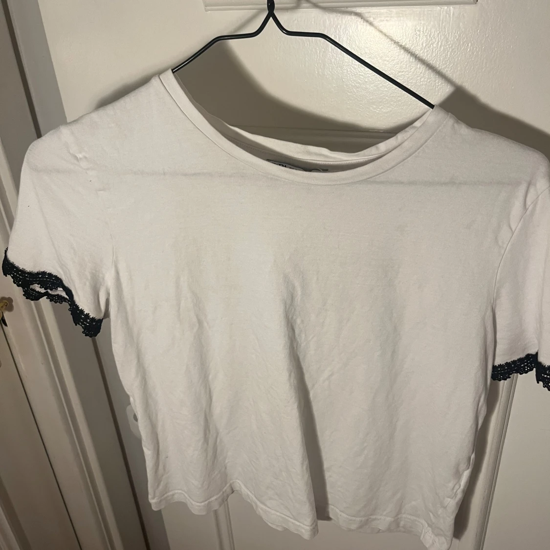 Vit topp med svarta spetsdetaljer
