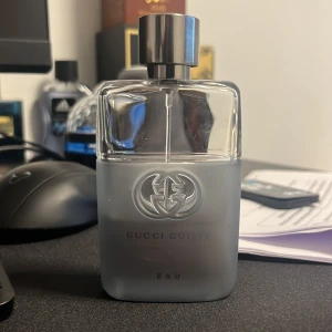 Gucci Guilty Eau Pour Homme EdT - Gucci Guilty Eau Pour Homme är en herrparfym med en stilren, genomskinlig glasflaska med frostad nedre del och silverfärgat lock. Flaskan har Guccis logotyp i relief och texten 'GUCCI GUILTY EAU' på framsidan.