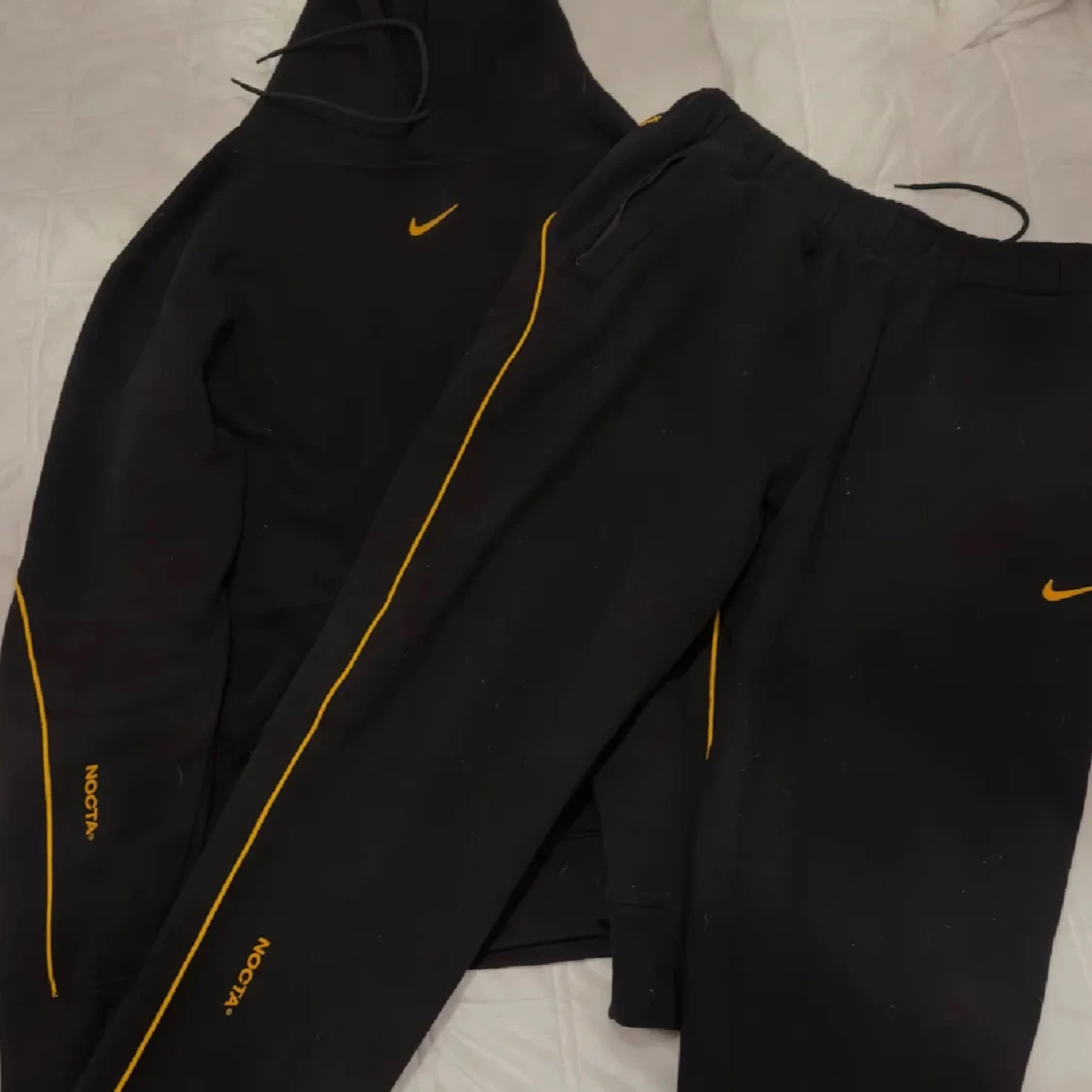 Svart hoodie från Nike NOCTA med gula detaljer
