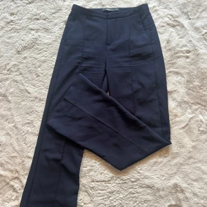Marinblå kostymbyxor från Gina Tricot - Marinblå kostymbyxor från Gina Tricot i storlek XS. Byxorna har bootcut, hög midja och pressveck framtill!💙