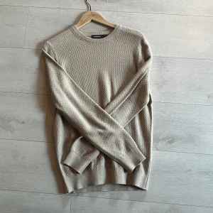 Beige stickad tröja från dressman - Säljer en stilren beige stickad tröja från dressman