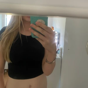 Svart croppad ribbad topp från FB Sister - Säljer en svart croppad topp från FB Sister i storlek XS. Toppen är ribbad och har korta ärmar, perfekt till jeans eller kjol. Enkel och stilren design som passar till många tillfällen.