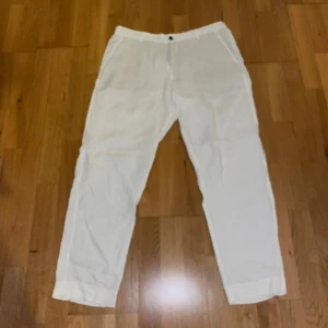 Zara linnebyxor  - Säljer ett par vita linnebyxor med normal passform. Byxorna har raka ben, knapp och dragkedja framtill samt fickor både fram och bak. Perfekta för varmare dagar och ger en avslappnad men stilren look.