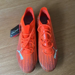 Puma Ultra fotbollsskor i orange - Säljer ett par Puma Ultra fotbollsskor FG storlek 41. Aldrig använda. 