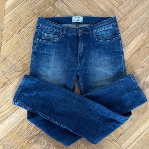 Blå jeans från Acne Studios - Snygga blå jeans från Acne Studios med en klassisk femficksdesign. De har en knappgylf och en lätt tvättad look som ger en avslappnad stil. Perfekta för en stilren vardagslook.