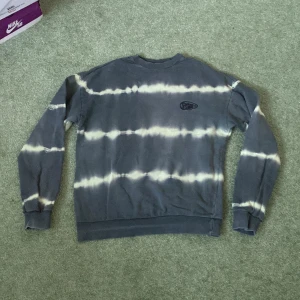 Grå batikmönstrad tröja från Take Care - Säljer en cool grå batikmönstrad tröja från Take Care. Tröjan har långa ärmar och ribbade muddar vid ärmslut och nederkant. Perfekt för en avslappnad stil. Hör av dig vid intresse!