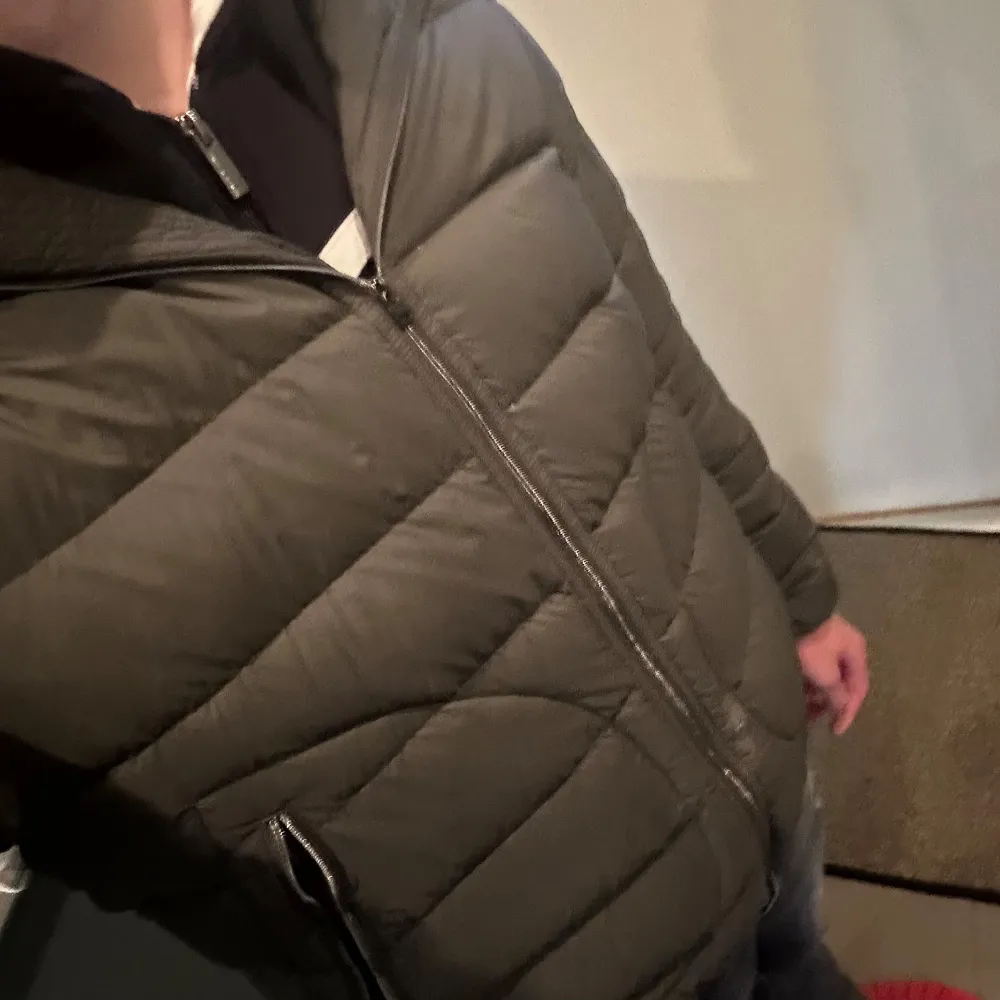 Säljer en snygg grön pufferjacka från Herno. Jackan har en quiltad design med dragkedja framtill och hög krage. Perfekt för kyliga dagar och ger en stilren look. Har ett litet hål (se bild 4) därav de billiga priset . Takit.