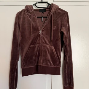 Brun juicy couture tröja - Säljer en snygg brun Juicy Couture tröja som ej varit så använd och har ej kommit till användning. Den är i storlek XXS men funkar som XS