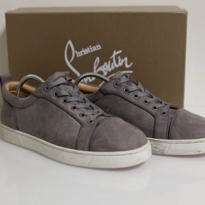 Christian Louboutin - Snygga grå sneakers från Christian Louboutin i mocka med den ikoniska röda sulan. Skorna har snörning och en stilren design som passar perfekt för en trendig look. Perfekta för dig som vill ha något exklusivt och modernt. Dem är använda vilket syns men ändå sjukt fina! Vid snabb affär kan man även få dem mycket billigare!