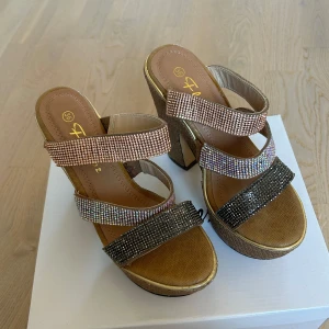 Högklackade skor/sandaletter - Fina skor som aldrig använts tidigare. Köptes i Grekland för något år sedan, så definitivt en one of a kind modell! Finns små tillverkningsfel som syns på bilderna av sulan. Annars mycket bra skick🤍