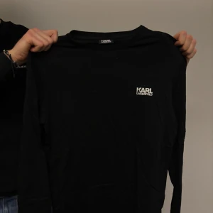 Svart långärmad tröja från Karl Lagerfeld - Snygg svart långärmad tröja från Karl Lagerfeld med logotyp på bröstet och nacken. Perfekt för en stilren look.