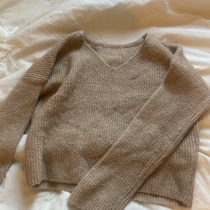 Beige stickad tröja med v-ringning - noppig