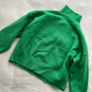 Grön polotröja från Zara - Säljer en snygg grön polotröja från Zara. Tröjan är stickad och har långa ärmar med ribbade muddar. Perfekt för att hålla sig varm och stilren under kyligare dagar. Passar utmärkt till både jeans och kjol. 🌿