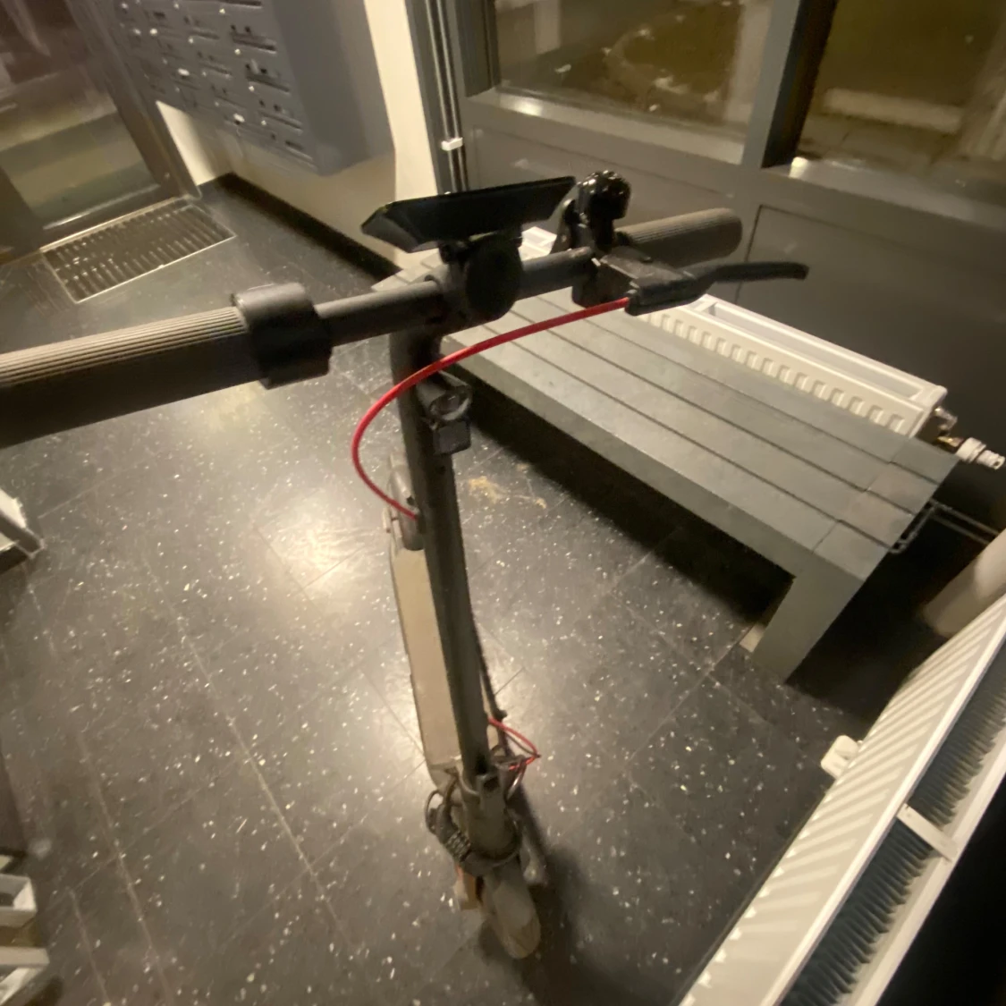 Grå elscooter med röd kabel åker i 60km ifall man trimmar 